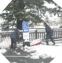 冬に駐車場の雪かきをしている場面