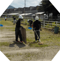 野外で草刈り機を使ったり、手で草むしりをしている場面